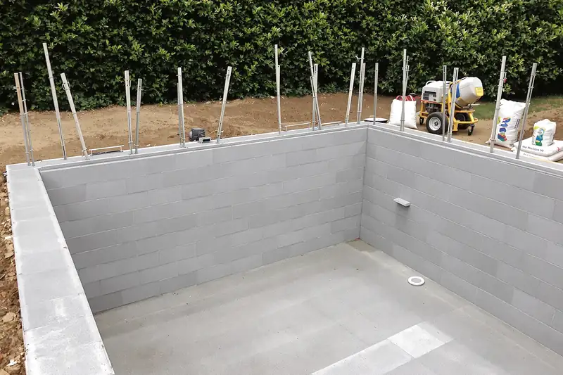 Murs de piscine en blocs à bancher avec fers en attente et pièces à sceller posées
